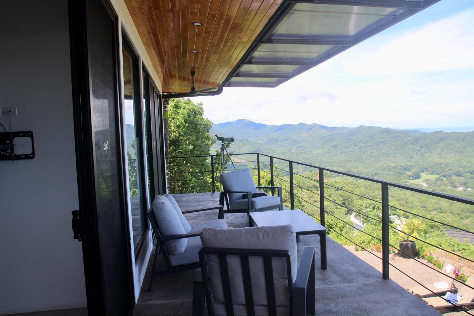 Casa Playa Carrillo — covered terrace with lounge seating and cable railing overlooking the hills