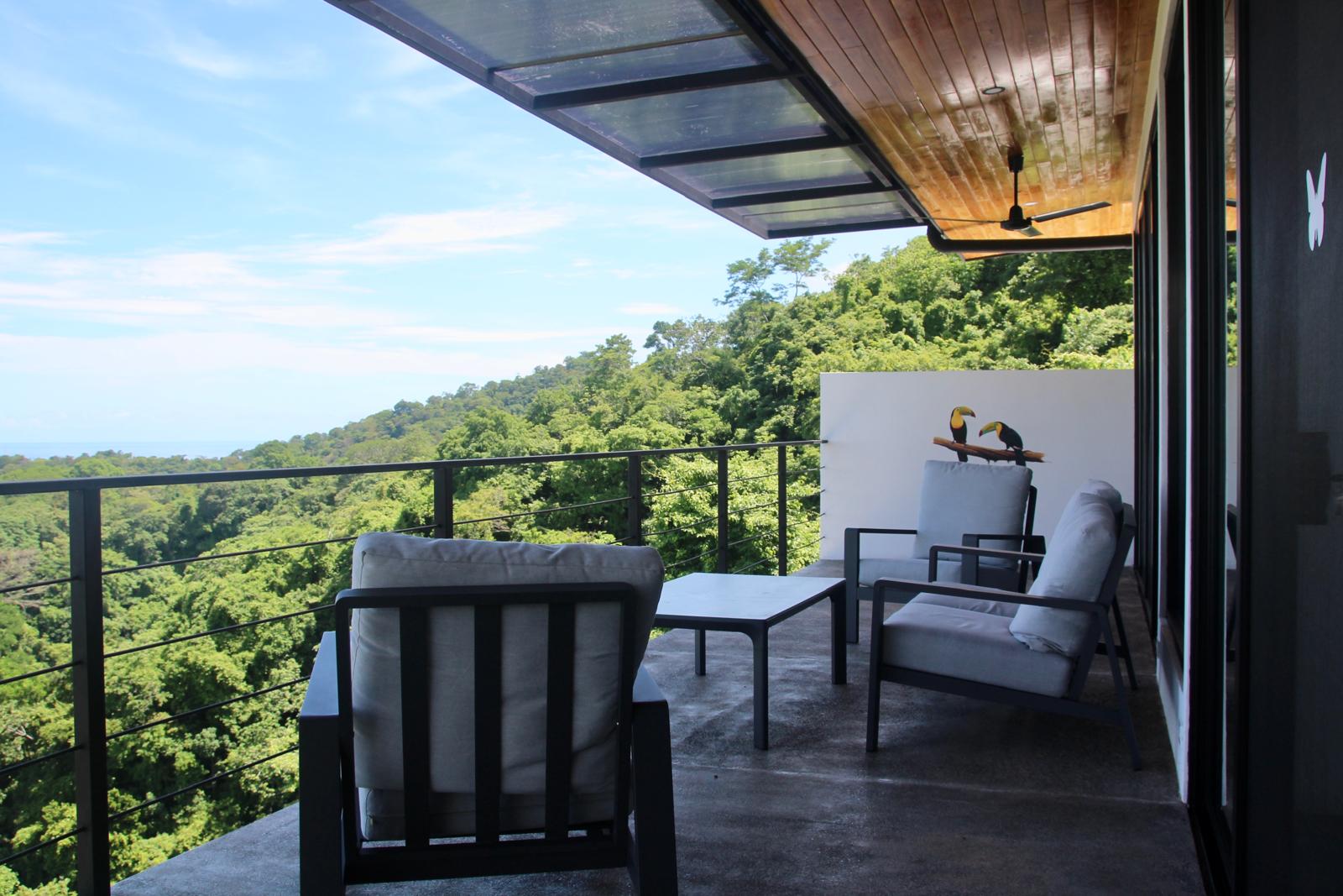 Casa Playa Carrillo — balcony lounge with views across the forest canopy to the coast